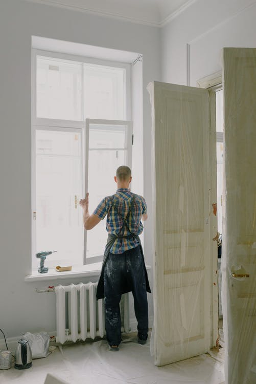 man is installing window